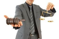 Man in suit holding gavel and scales of justice
