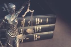 Lady justice figure in front of books